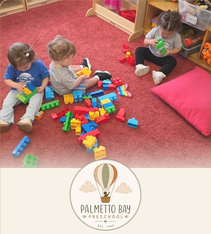 Young toddlers building with blocks on the classroom rug